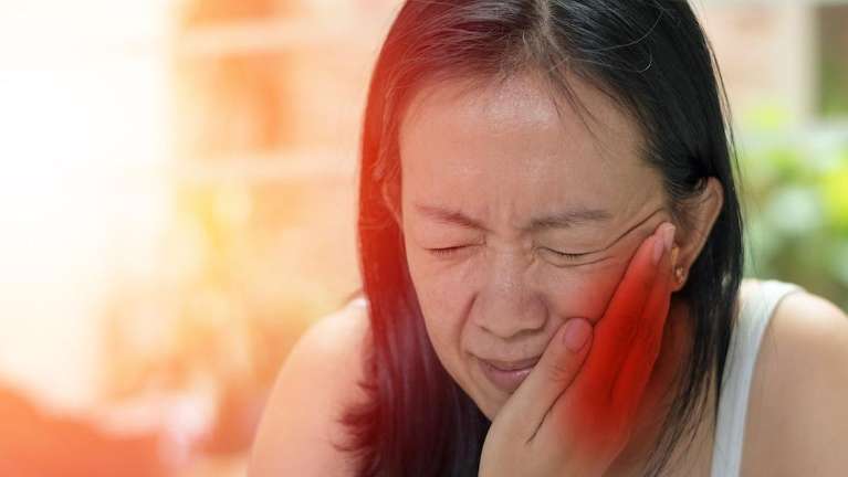 an asian woman with a toothache in Avondale